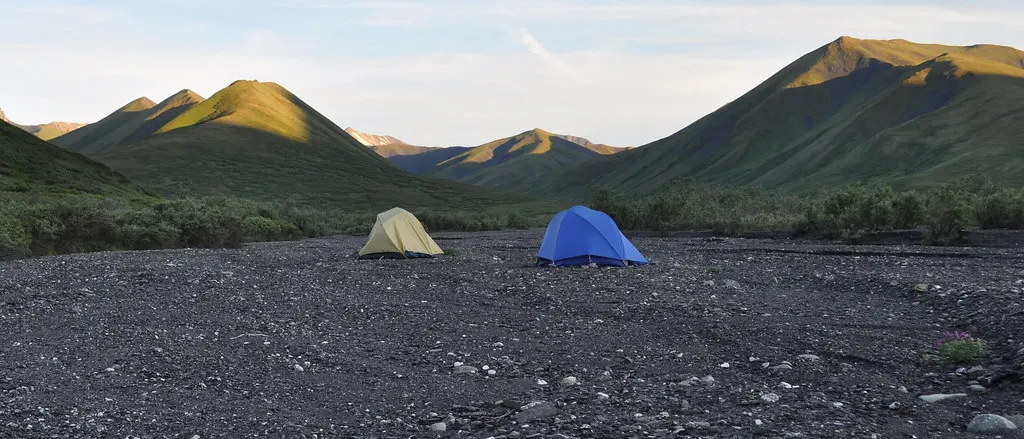 Dağlık bir vadide çakıllı zemine kurulmuş iki kubbe tipi 3 mevsim trekking çadırı